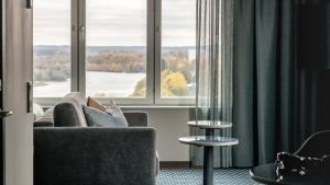 a person sitting on a couch looking out of a window at Clarion Hotel Umeå in Umeå