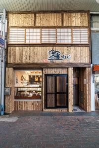 un negozio di fronte a un edificio con porte in legno di 久宿　白川 a Kyoto