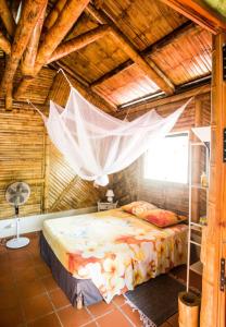 a bedroom with a bed with a mosquito net at Shuit Bambou in La Trinité