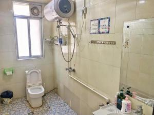een badkamer met een douche, een toilet en een wastafel bij House of Wisdom in Renhua