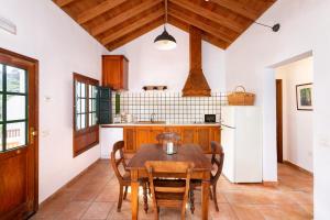 Las Casas del Chorro في Agulo: مطبخ مع طاولة وكراسي وثلاجة