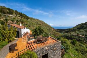 a house with a balcony with a table and chairs at Las Casas del Chorro in Agulo