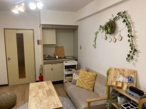 a living room with a couch and a table and a kitchen at 副都心線池袋駅C1出口から徒歩3分 1か月以上のご予約は6割Off in Tokyo