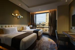 a hotel room with two beds and a window at The Granite Luxury Hotel Penang in George Town