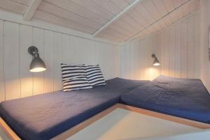 two twin beds in a room with two lights at Sommerhus i Marielyst m/Spa og sauna - tæt på by og strand in Marielyst