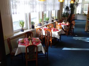 a dining room with tables and chairs and windows at Hotel Waldmühle in Elend