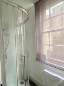 a bathroom with a shower and a sink and a window at Arlington Villas Townhouse by Clifton Short Lets in Bristol