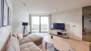 a living room with a couch and a tv and a table at Pinea, Sun & Snow in Pobierowo