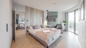 a bedroom with a large bed and a living room at Pinea, Sun & Snow in Pobierowo