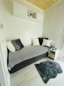 Dormitorio pequeño con cama y alfombra en Voralpen Lodge - Ferienhaus mit Gym, Sauna & Hot Tub, en Traisen