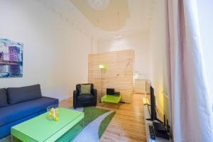 ein Wohnzimmer mit einem blauen Sofa und einem Tisch in der Unterkunft Urban Pistazie in Berlin