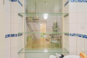 a bathroom with a glass shelf in a window at Urban Pistazie Kreuzberg in Berlin