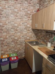 a kitchen with a sink and a brick wall at First Station 26-11 in Krakow