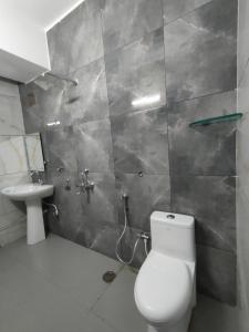 Hotel Crown Inn في دهرواد: حمام مع مرحاض ومغسلة