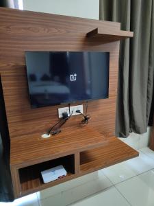 uma televisão de ecrã plano num centro de entretenimento em madeira em Hotel Crown Inn em Dharwad