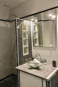 baño con lavabo y espejo en LE BROOKLYN - Studio Centre Ville avec climatisation et connexion Wifi, en La Grande-Motte