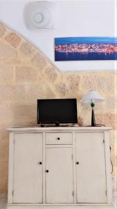 a white cabinet with a television on top of it at Bed & Breakfast Porta d'Oriente in Brindisi