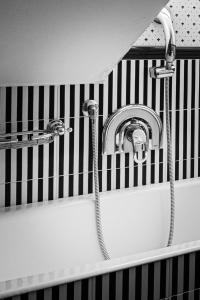 a bathtub with a hose hooked up to a sink at Hotel Petite Fleur in Roccaraso