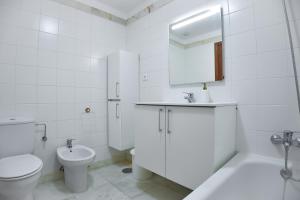 a white bathroom with a toilet and a sink at Lido Gardens Funchal in Funchal +15 photos
