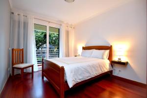a bedroom with a bed and a window at Lido Gardens Funchal in Funchal