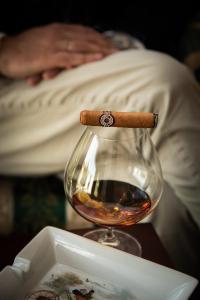 a cigar sitting on top of a glass of alcohol at Hotel Petite Fleur in Roccaraso