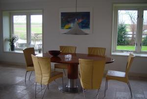 a dining room with a wooden table and chairs at Piaam State in Piaam