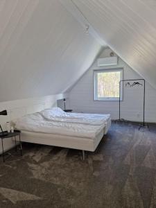 a white bedroom with a bed and a window at Fräscht, spatiöst hus in Visby
