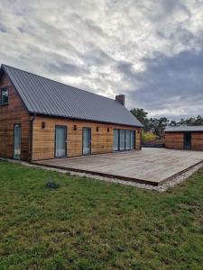 a wooden house with a large deck in front of it at Fräscht, spatiöst hus in Visby