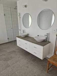 a bathroom with two sinks and two mirrors at Fräscht, spatiöst hus in Visby
