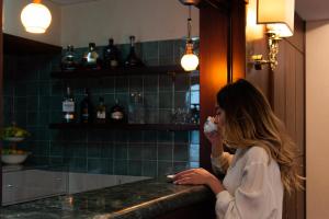 a woman standing at a counter in a kitchen at Hotel Petite Fleur in Roccaraso