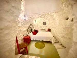 a room with a bed in a stone wall at Cueva con vistas a la Alhambra in Granada