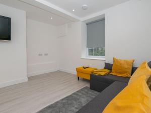 een woonkamer met een bank en gele kussens bij The Suffolk-uk41441 in Brandon
