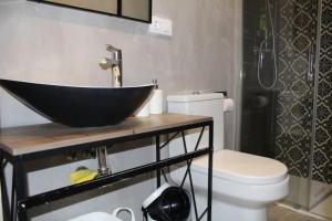 een badkamer met een zwarte wastafel en een toilet bij CDZ - Casa de los Viajeros Pasquín in Cádiz