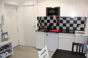 uma cozinha com uma parede xadrez em preto e branco em CDZ - Casa de los Viajeros Pasquín em Cádiz