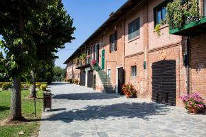 una acera junto a un edificio de ladrillo con flores en Agriturismo La Margherita, en Carmagnola