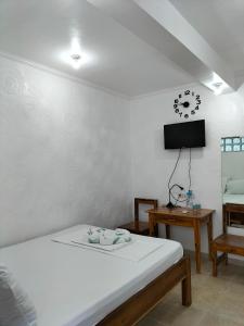 a bedroom with a bed and a tv on the wall at Princess of Coron Austrian Resort in Coron