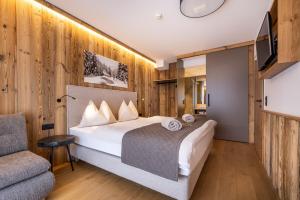 Habitación de hotel con cama y silla en Ferienanlage Central en Flachau