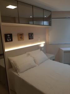 um pequeno quarto com uma cama com uma luz por cima em Apartamento Estilo Prime em Salvador