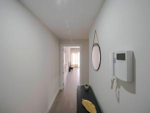 Habitación blanca con sofá negro y espejo en Home Luxury fjHomefj, en Jerez de la Frontera