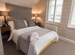 a bedroom with a large bed and two windows at The Bear, Cowbridge in Cowbridge