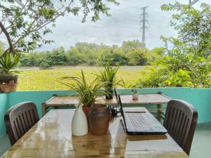 d'une table avec un ordinateur portable. dans l'établissement Cu Chi Boutique Farmstay, à Hô-Chi-Minh-Ville