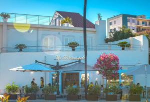 a restaurant with umbrellas in front of a building at La Promenade Rooms & Suites in Olbia