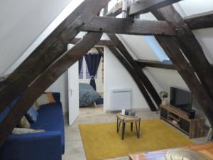 a living room with a blue couch and a tv at Gîte d’Eros in Saint-Valery-sur-Somme