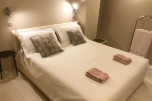1 cama blanca grande con 2 toallas en Budello di Alassio, ampio appartamento con box, en Alassio
