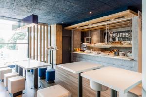 ein Restaurant mit weißen Tischen und weißen Stühlen in der Unterkunft ibis budget Lyon Gerland in Lyon