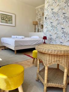 a bedroom with a bed and a table and chairs at Hôtel Clair de Lune in Mauguio