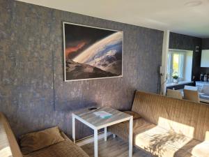 salon ze stołem i obrazem na ścianie w obiekcie Domek Lipek w Ustroniu