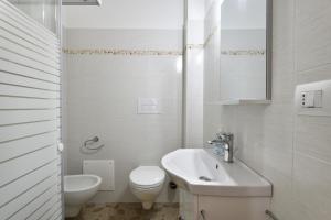 Baño blanco con aseo y lavamanos en Casa Vacanze Bonu Iloghe, en Dorgali