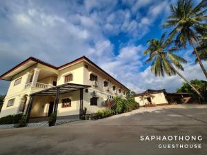 a building with a palm tree in front of it at Saphaothong guesthouse in Vang Vieng