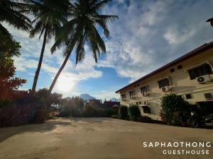 a palm tree and a building with a palm tree at Saphaothong guesthouse in Vang Vieng
